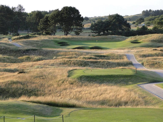 Evening sunlight over the dune lined 1st hole at Southport and Ainsdale Golf Club, with golden rough, pot bunkers and a raised green among the sandhills
